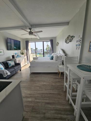 a bedroom with a bed and a couch and a table at Salty Love Nest in Fort Walton Beach