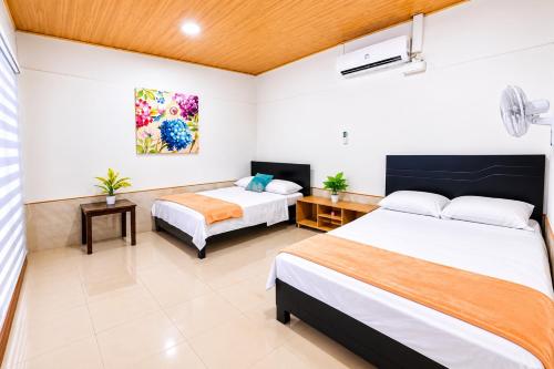 a hotel room with two beds and a desk at Escápate a Jacó apartamento completo in Jacó