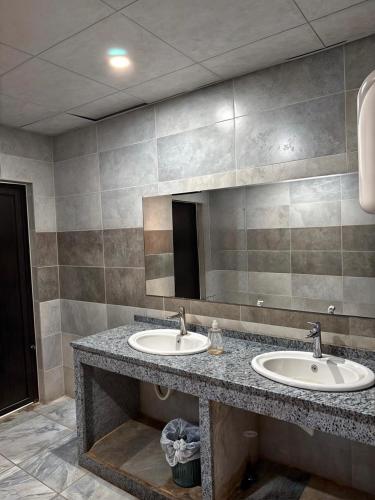 a bathroom with two sinks and a large mirror at RUM PRESTIGE lUXURY CAMP & DESERT TOURS in Wadi Rum