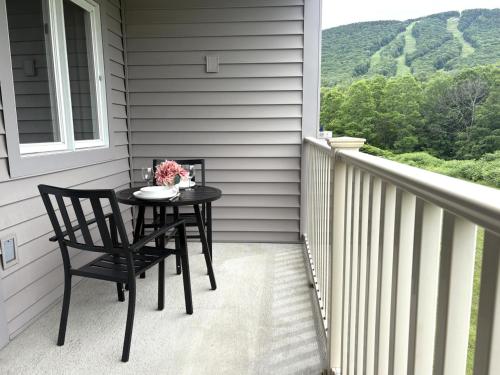 a table and a chair on a porch at Loon Resort Condo-AC, Pool, Hot Tub and Views in Lincoln