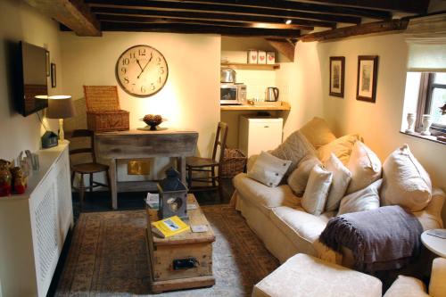 a living room with a couch and a clock on the wall at Riverside House in Norwich