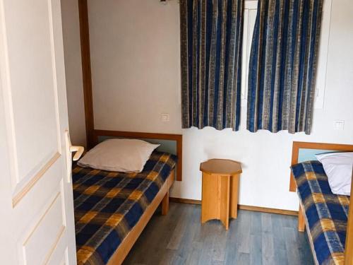 a bedroom with two beds and a window at Chalets avec Animaux, Terrasse et Parking - FR-1-489-323 in Échassières
