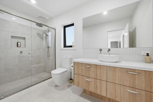 a bathroom with a toilet and a sink and a shower at Inverloch Seaside Escape in Inverloch