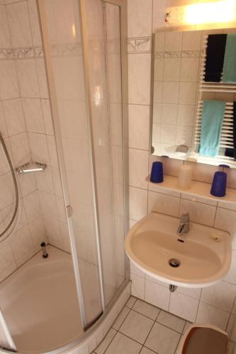 a white bathroom with a sink and a shower at Ferienhof Lafrenz in Cuxhaven