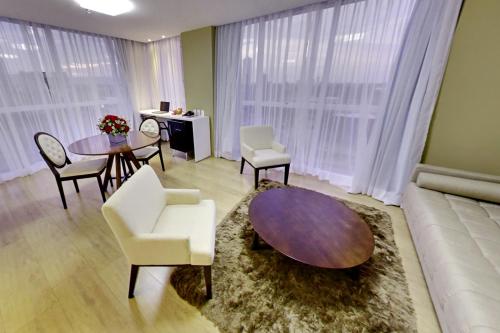 a living room with a couch and a table and chairs at Select Hotel in Palmas