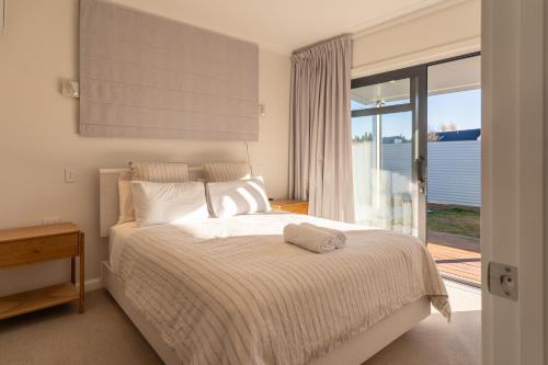 a bedroom with a bed and a sliding glass door at Twizel Cottages in Twizel