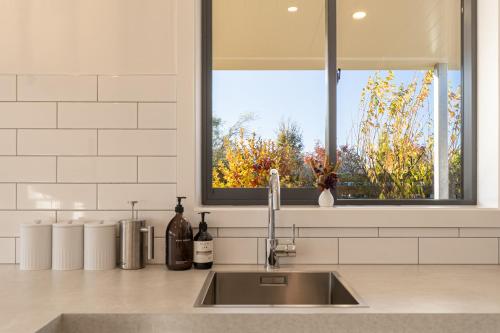 a kitchen counter with a sink and a window at Twizel Cottages in Twizel