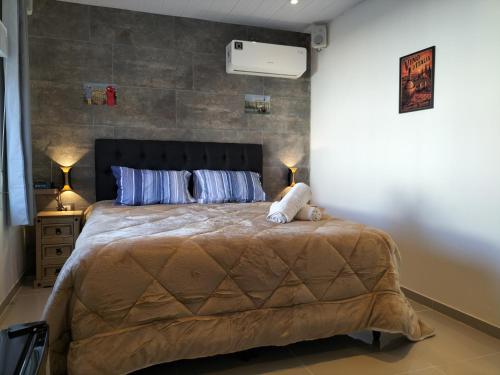 a bedroom with a large bed with two pillows at Toscana Apartamentos in Progreso