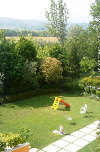 a playground with a slide and chairs in a yard at Albergo Le Piante in Manerba del Garda
