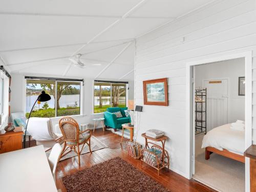 a bedroom with a bed and a living room at River Cottage in Mylestom