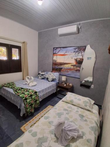 a bedroom with two beds and a mirror on the wall at Garden House - Atins in Atins