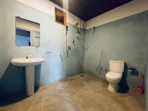 a bathroom with a toilet and a sink at Kora Beach House & Restaurant Cafe in Ampara