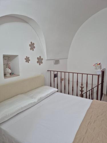 a white bed in a room with a staircase at CV MiRa house in Putignano