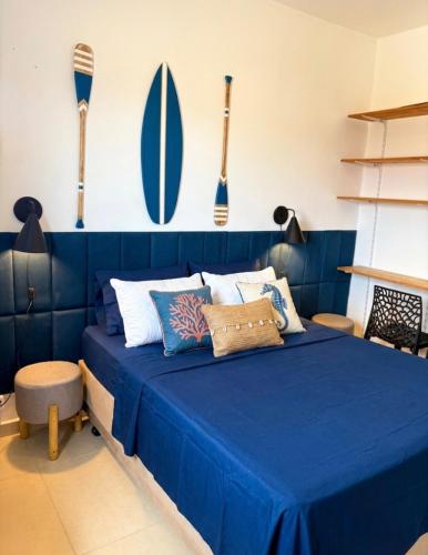 a blue bed in a room with surfboards on the wall at Apartamento Centro Bertioga Casal e Família - Ar Condicionado - Praia da Enseada in Bertioga