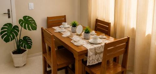 a dining room table with chairs and a table with a tablecloth at Meu Aconchego - Araruama 2 quartos - Vaga- Wi-Fi in Araruama