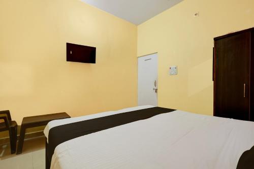 a bedroom with a bed and a tv on the wall at Hotel O Royal Inn Hotel in Hāpur
