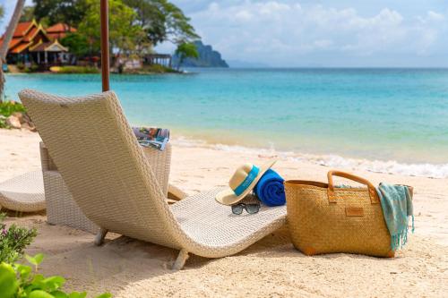 a pair of chairs and a purse on the beach at OUTRIGGER Phi Phi Island Resort in Phi Phi Islands