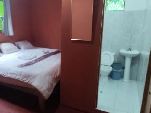a bedroom with a bed and a bathroom with a sink at Etrita Inkas Hostel in Sahuayacu