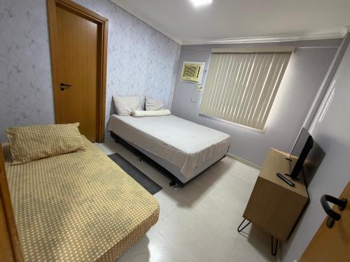 a small room with a bed and a window at Garden aconchegante in Manaus