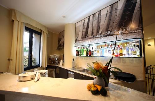 a kitchen with a counter with a bar with bottles at Hotel San Rocco in Muggia