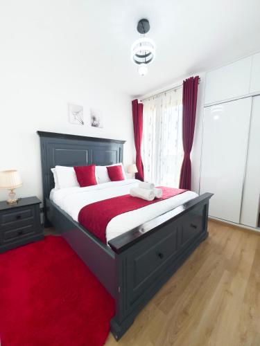 a bedroom with a large bed with a red rug at Capitalcribs in Tatu City