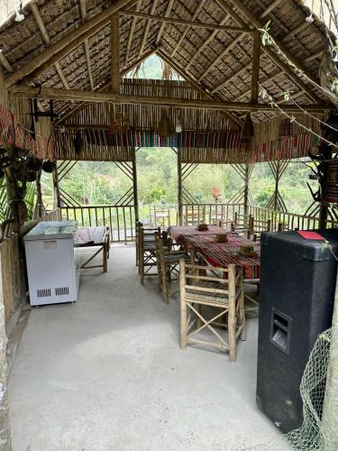 a pavilion with a table and chairs in it at Homestay mây phía đồi in Lũng Tiềm