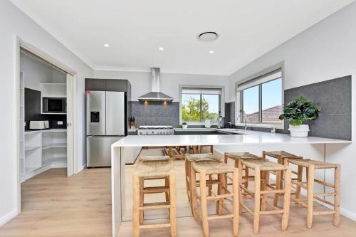 a kitchen with a large white table and chairs at Finns at Caves Beach Resort in Caves Beach