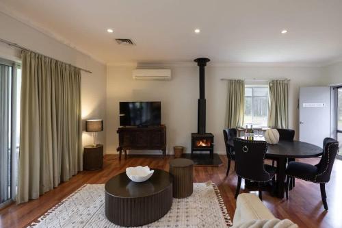 a living room with a table and a fireplace at Gartelmann Studio at Gartelmanns Wines in Rothbury
