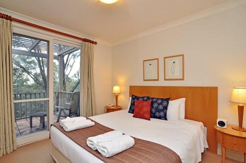 a bedroom with a bed with two towels on it at Villa 1br Merlot Villa located within Cypress Lakes Resort in Pokolbin