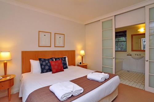 a bedroom with a large bed with towels on it at Villa 1br Merlot Villa located within Cypress Lakes Resort in Pokolbin