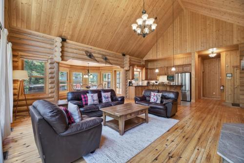a living room with leather furniture and a wooden ceiling at Fiddler Lake Resort - Deer 30 in Mille-Isles
