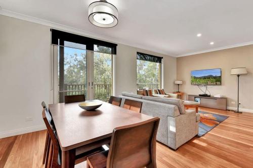 a living room with a table and a couch at Villa 2br Pinot Nois Villa in Pokolbin