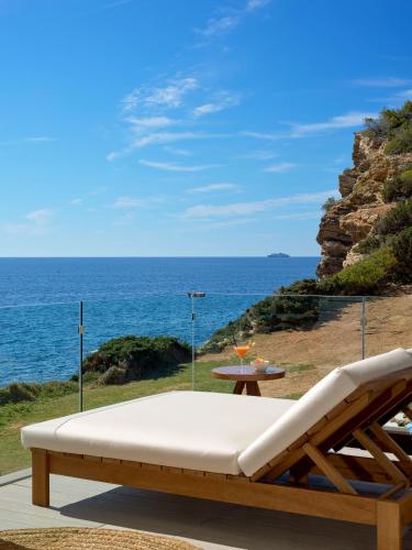 a bench sitting on a patio overlooking the ocean at Meliá Ibiza - Adults Only in Santa Eularia des Riu
