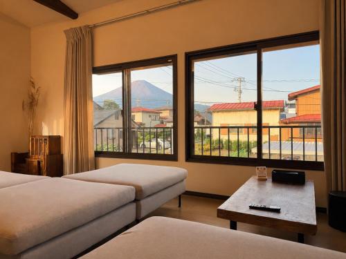 a hotel room with two beds and a large window at Three Maples Fujiyoshida in Fujiyoshida