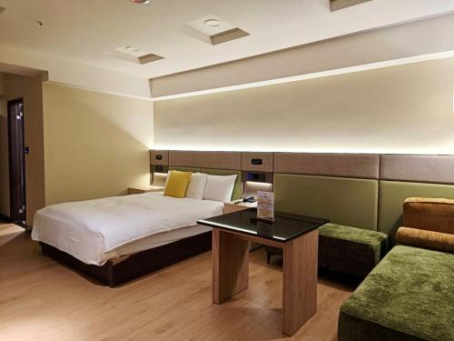 a bedroom with a bed and a table and a couch at Fosen Hotel in Taichung