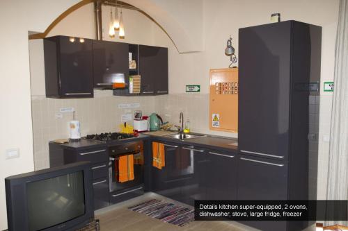 ローマにあるApartment Monticelliのキッチン(黒いキャビネット、テレビ付)