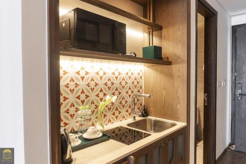 a kitchen with a sink and a microwave at Mandala Pearl Resort in Phan Thiet