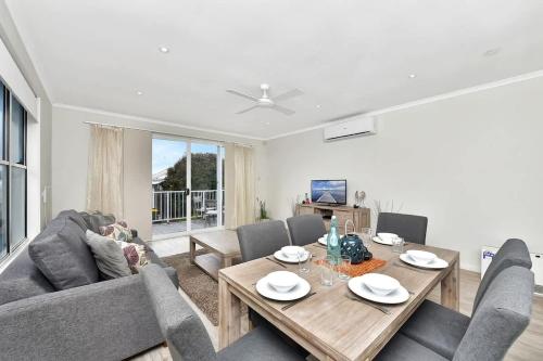 a living room with a couch and a table at Beach Escape at Caves Beach Villas in Caves Beach