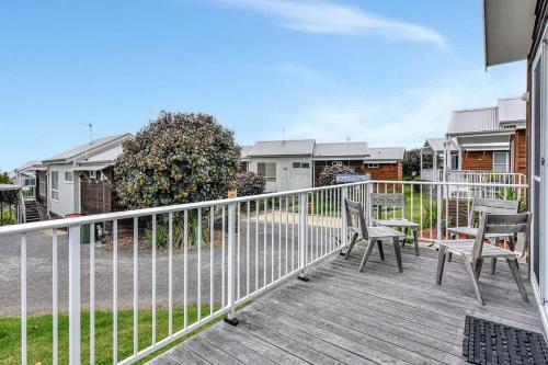 a porch with two chairs and a fence at Beach Escape at Caves Beach Villas in Caves Beach