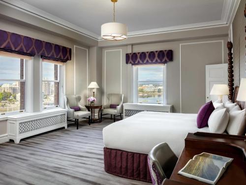 a hotel room with a large bed and windows at Fairmont Empress Hotel in Victoria