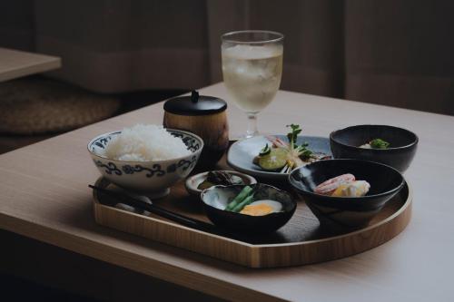 a tray with bowls and rice and a glass of water at 纏matoi in Maizuru