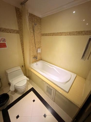 a bathroom with a bath tub and a toilet at CT Suite in Pattaya South