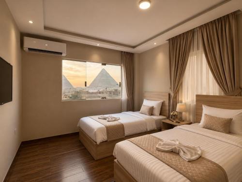 a hotel room with two beds with a view of the pyramids at Royal Aida Pyramids View INN in Cairo