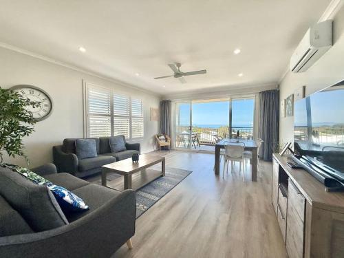 a living room with a couch and a table at Ocean Mist at Caves Beach Villas in Caves Beach