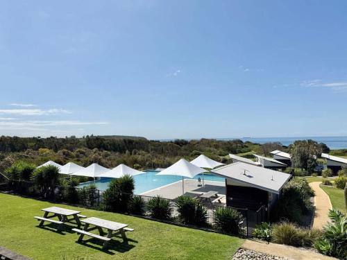 an aerial view of a resort with a pool and tents at Ocean Mist at Caves Beach Villas in Caves Beach