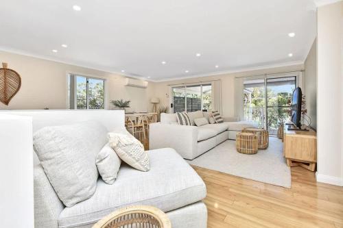 a living room with a white couch and a table at Upper Deck On Dobell in Wangi Wangi