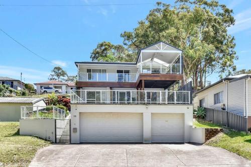a house with a balcony on top of a garage at Upper Deck On Dobell in Wangi Wangi