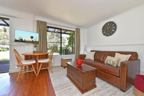 a living room with a couch and a table at Olive Grove 1 Studio in Pokolbin