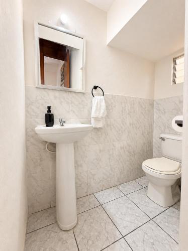 a bathroom with a sink and a toilet at Gosen Stays in Antiguo Cuscatlán