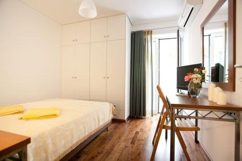 1 dormitorio con 1 cama y escritorio con TV en Veggie Garden Athens B&B en Atenas